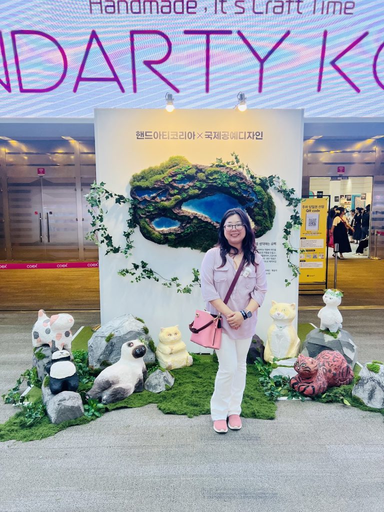 Ara Ko Lopez posing at the Handarty Korea entrance display during the annual handmade craft exhibition in Seoul.