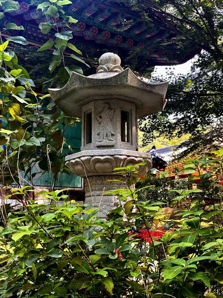 Stone lantern surrounded by greenery on the grounds of Sudeoksa Temple